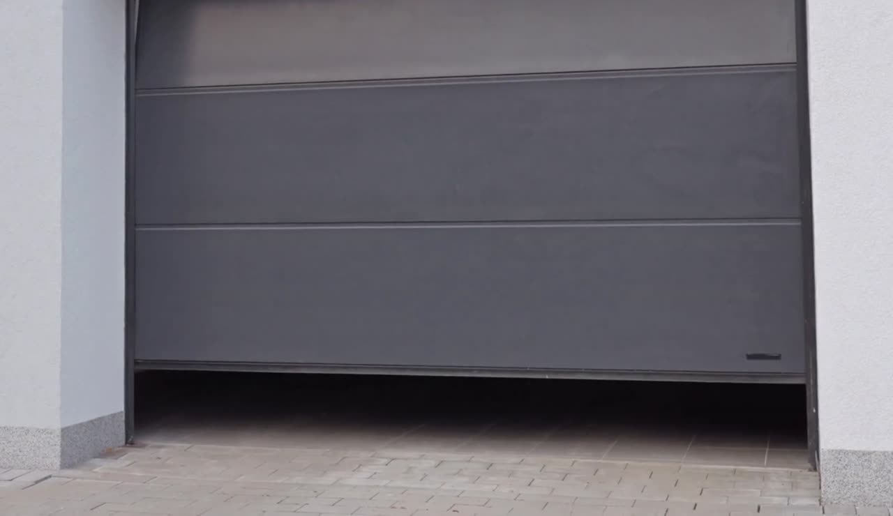 A modern grey garage door closing smoothly by remote